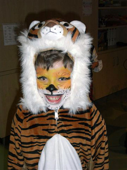 Ein Kind trägt ein Tiger-Kostüm und ist wie diese Wildkatze geschminkt.