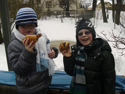 Zwei Jungs genießen ihre Bratwurst.