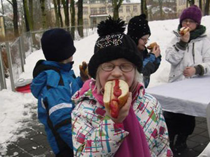 Ein Mädchen beißt genüsslich in ihre Bratwurst mit Ketchup.