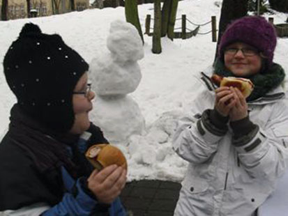 Zwei Kinder lassen sich ihre Bratwurst schmecken.