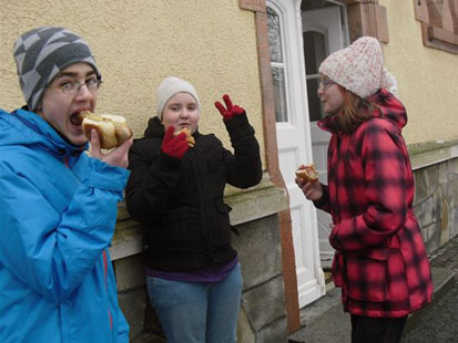 Drei Jugendliche lassen sich ihre Bratwurst schmecken.