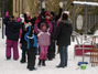 Viele Kinder stehen im Schnee und melden sich.