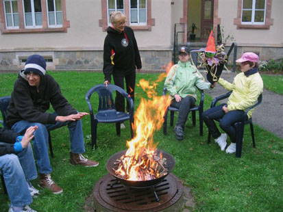 Die Kinder sitzen im Stuhlkreis um das Lagerfeuer und wärmen sich.