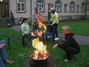 Die Betreuerin legt Holz beim Lagerfeuer nach.