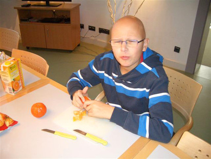 Junge schält eine Mandarine.