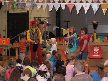 Ein Clown führt den Kindern Zaubertricks vor.