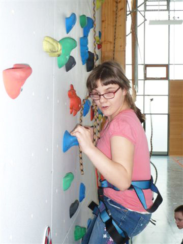 Mädchen klettert an der Wand nach oben