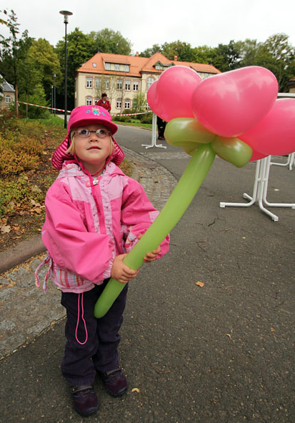 Mädchen hält eine große Luftballonblume in den Händen