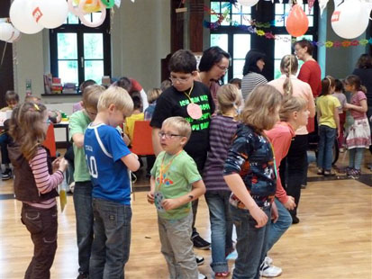 Kinder bewundern ihre gebastelten Medaillen